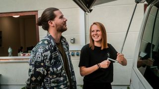 Junge Frau testet die Markise eines Campers vor dem Campingbus kaufen